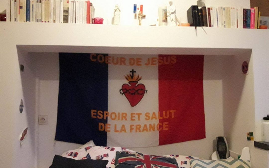 Un drapeau français orné de symbole catholique décore la chambre de Nicolas./photo: Alan Bernigaud