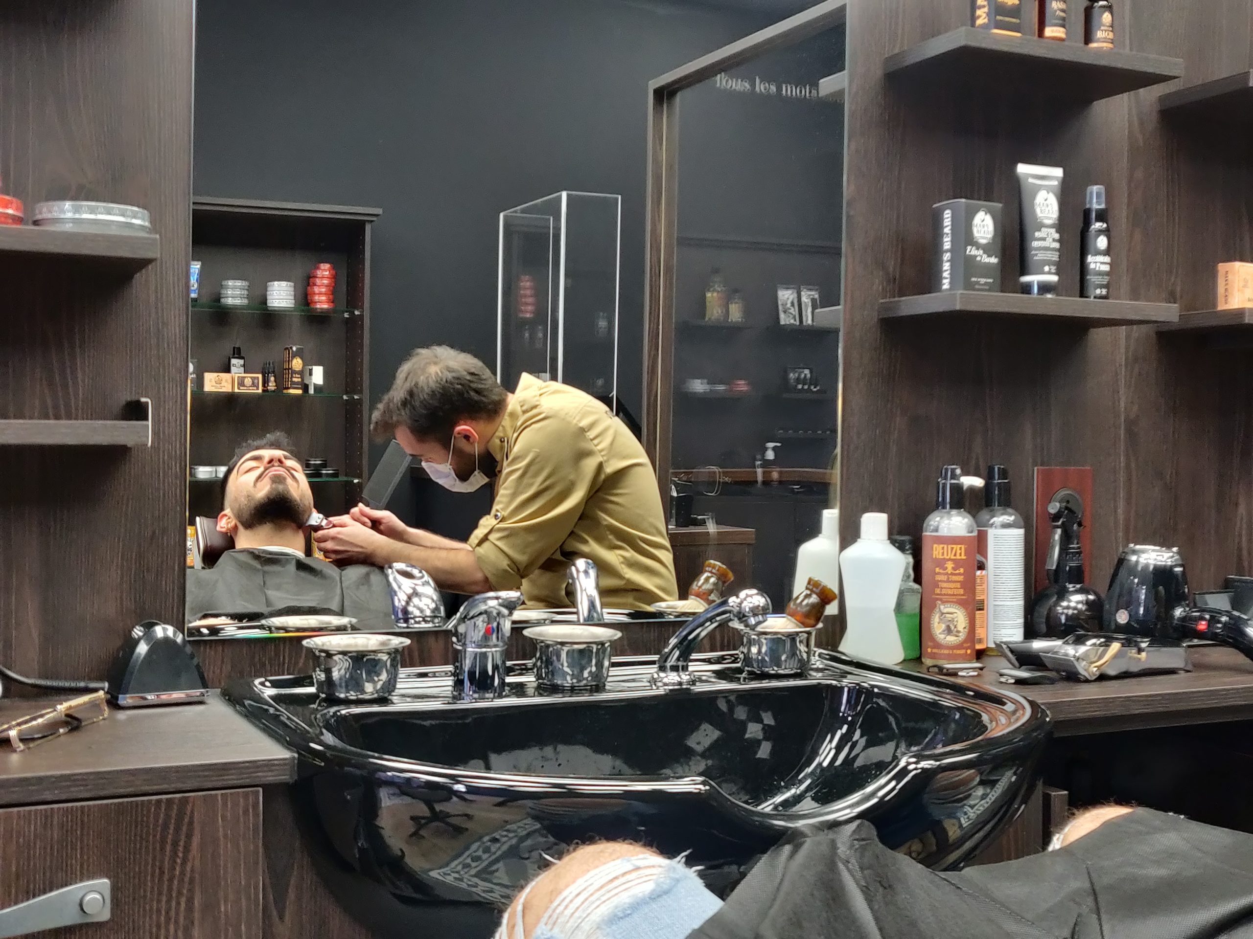 Les barbiers retaillent la barbes de leurs clients même en période de Covid. / Crédit : Bary Isaac