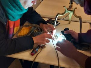 Jean-Baptiste Munoz aide une habituée à réparer sa lampe ©Emeline Lagarde