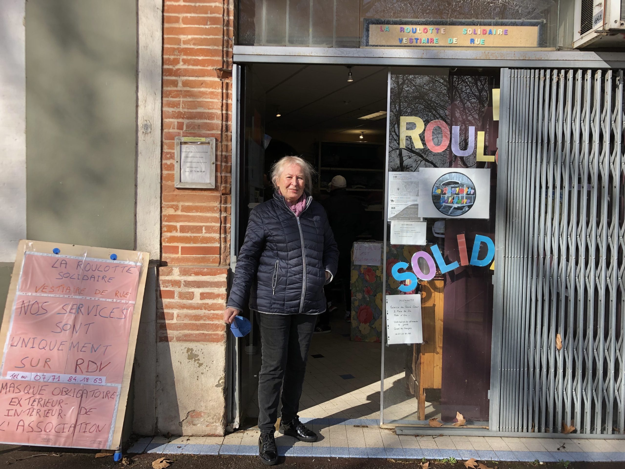 Monique, la présidente de l'association 'La Roulotte Solidaire' devant le local