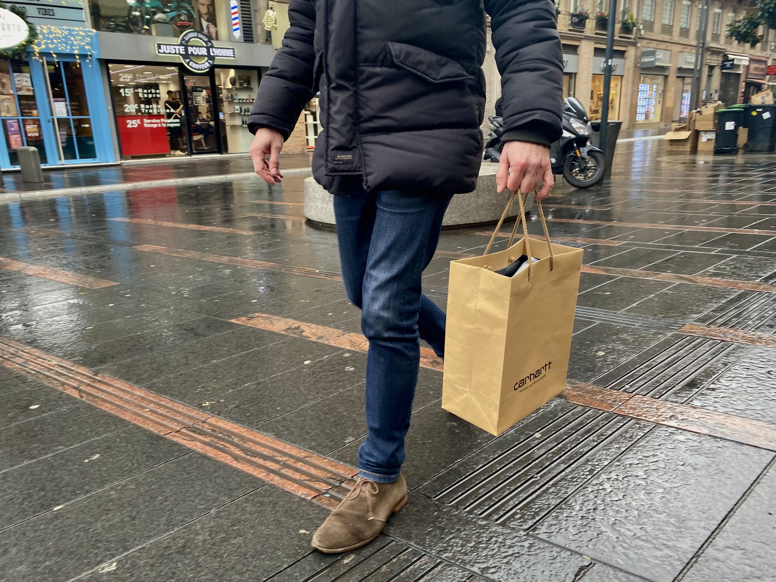 Homme avec un sac qui vient de faire les soldes.