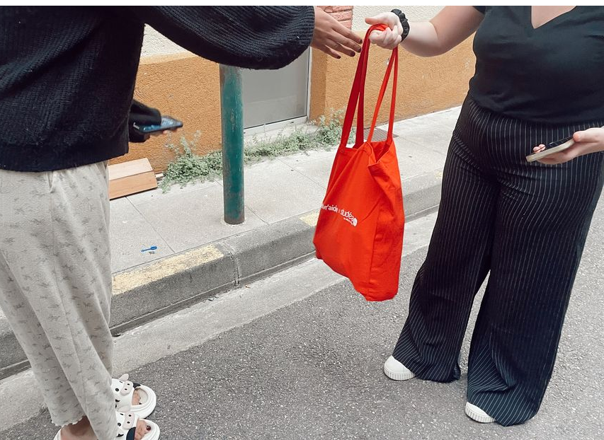 Une étudiante reçoit son panier étudiant avec de la nourriture gratuite.